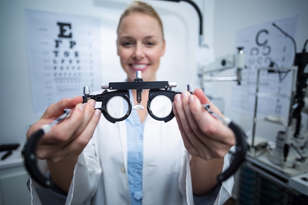 Zdjęcie uśmiechnięty żeński optometrist mienia messbrille