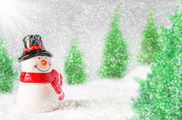 Uśmiechy szczęścia bałwana i opadów śniegu w lesie sosnowym na Boże Narodzenie.