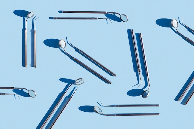 Zdjęcie ustaw medyczne narzędzie stomatologiczne niebieskie tło. wzór. leczenie sondą lustrzaną, higiena, badanie jamy ustnej.