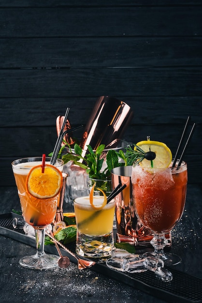 Zdjęcie ustaw na koktajlach alkoholowych w barze na czarnym drewnianym tle