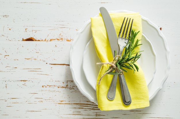 Ustawienie stołu wiosna z rozmarynem i żółtą serwetką