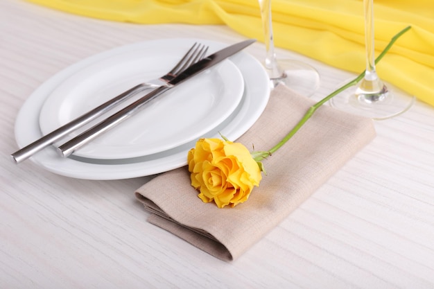 Ustawienie stołu z żółtą różą na talerzu