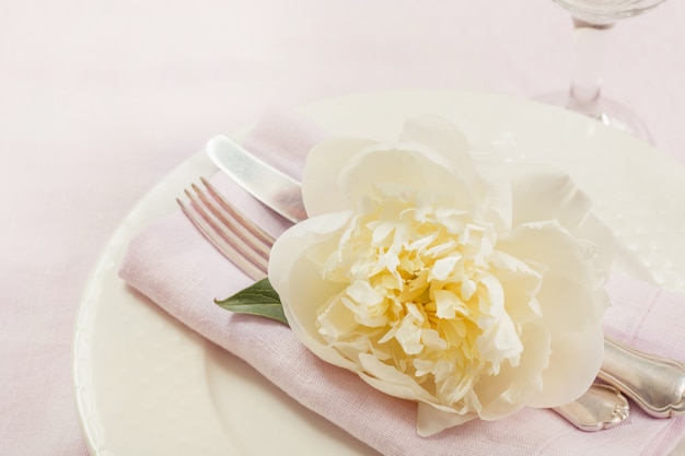 Ustawienie tabeli elegancji z roślin na różowy obrus lniany