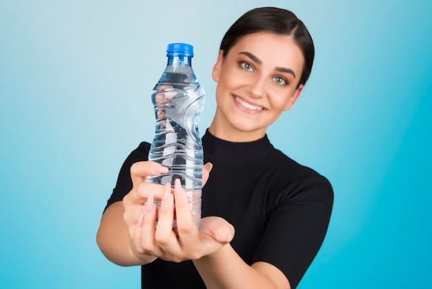 Utrzymywanie uwodnionej wody to koncepcja życia, zdrowy styl życia, dobre nawyki. kobieta trzyma butelkę wody