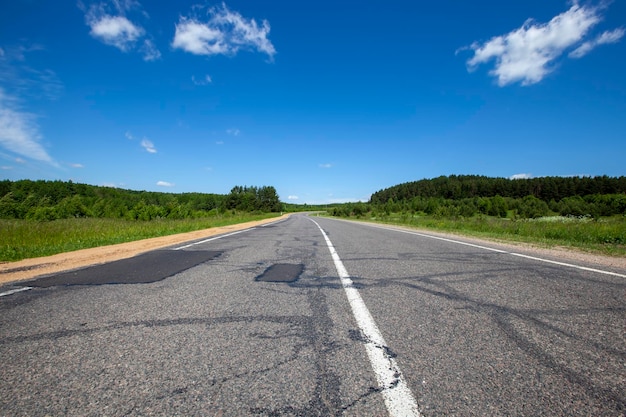 Utwardzona autostrada z błękitnym niebem i chmurami