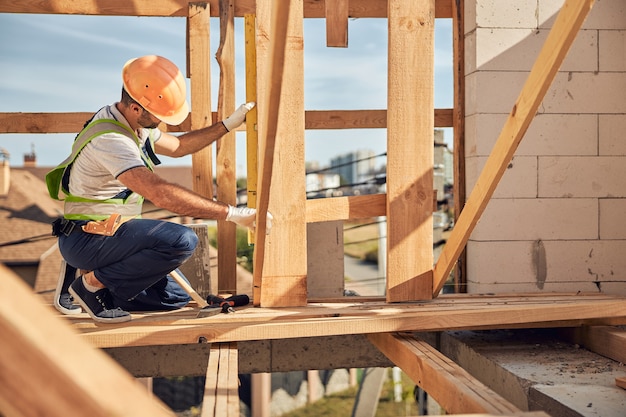 Uważny konstruktor pochyla głowę podczas ciężkiej pracy przy budowie osiedla