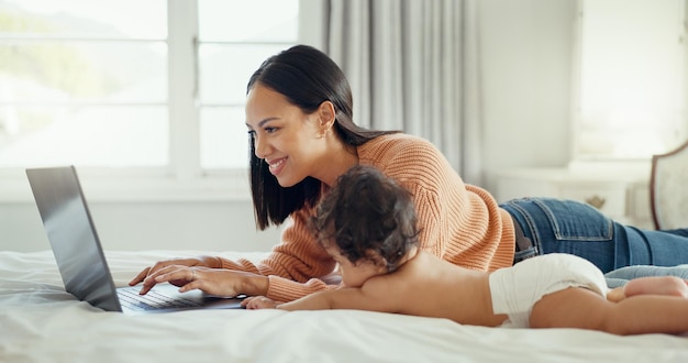 Uwielbiam laptopa i matkę z dzieckiem w łóżku, aby nawiązać więź, zrelaksować się i bawić w domu Rodzinne media społecznościowe i wpływowa mama z noworodkiem w sypialni i tworzenie treści na blogu online