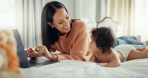 Uwielbiam laptopa i matkę z dzieckiem w łóżku, aby nawiązać więź, zrelaksować się i bawić w domu Rodzinne media społecznościowe i wpływowa mama z noworodkiem w sypialni i tworzenie treści na blogu online