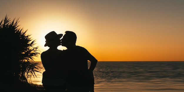 Uwielbiany przez zakochaną parę nad morzem, która bawi się sobą o zachodzie słońca
