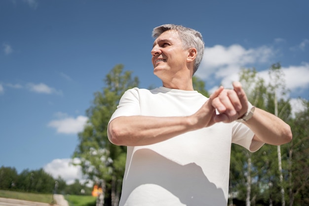 Używa zegarka fitness na ramieniu starszego mężczyzny trenującego sport