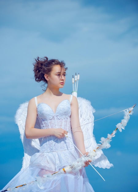 Valentin angel teen girl w białej sukni aniołów ze skrzydłami. Valentines nastolatek dziewczyna z łuku strzałką.