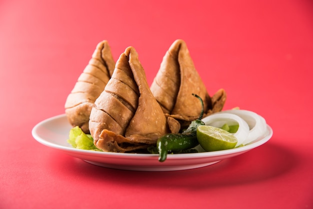 Veg Samosa - to chrupiąca i pikantna indyjska przekąska w kształcie trójkąta, która ma chrupiącą zewnętrzną warstwę maida i nadzienie z puree ziemniaczanego, groszku i przypraw.