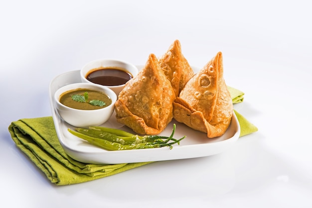 Veg Samosa to popularna indyjska przekąska lub fast food, podawana z smażonym zielonym chilli, cebulą i chutneyem lub ketchupem