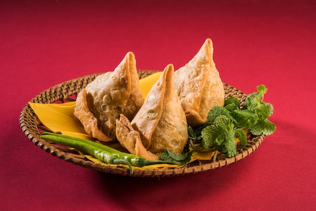 Veg Samosa to popularna indyjska przekąska lub fast food, podawana z smażonym zielonym chilli, cebulą i chutneyem lub ketchupem