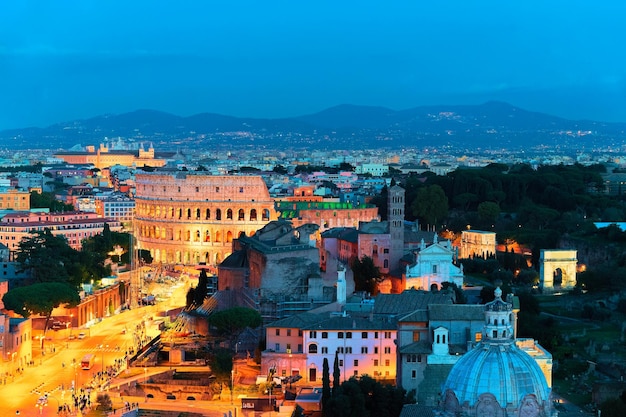 Via dei Fori Imperiali i Koloseum w centrum Rzymu, Włochy. Wieczorem