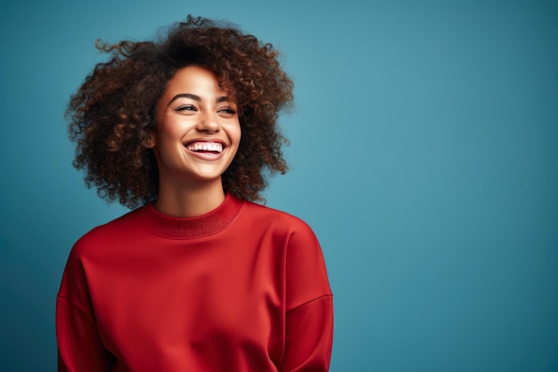Vibrant Joy Uśmiechnięta afroamerykańska kobieta w czerwonym swetrze Niebieski tło z przestrzenią do kopiowania