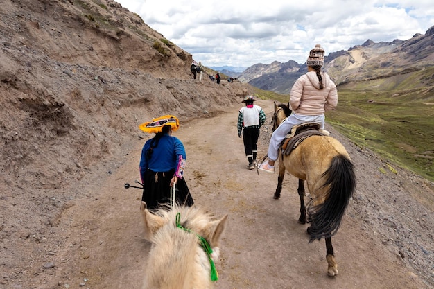 VinkunkaCusco Peru Peruwińscy szerpa zabierają turystów na koniach wzdłuż drogi w pobliżu gór