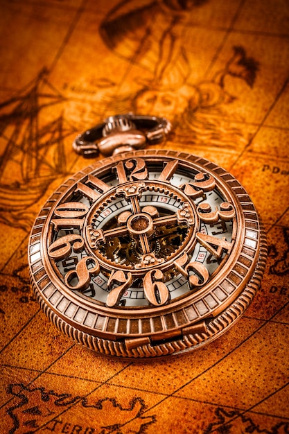 Vintage Antique zegarek kieszonkowy na starożytnej mapie świata z 1565 roku.