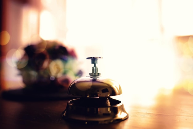 Vintage dzwonek stoi na drewnianym blacie, aby przyciągnąć uwagę
