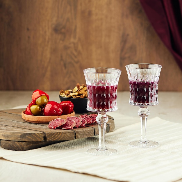 Zdjęcie vintage kieliszki z czerwonym winem i smacznymi przekąskami na stole