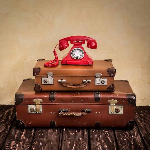 Vintage klasyczna brązowa skórzana walizka i telefon retro. Koncepcja biznesowa biura podróży