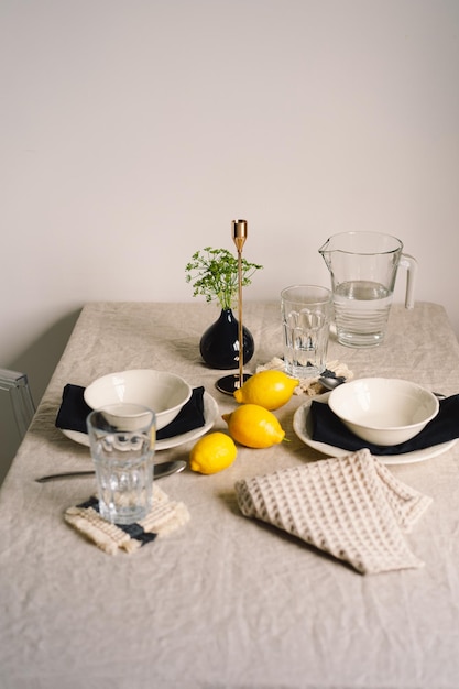 Vintage nakrycie stołu z lnianymi serwetkami i żółtymi cytrynami Dekoracja stołu z bliska Przytulny spokojny posiłek rano w promieniach słońca