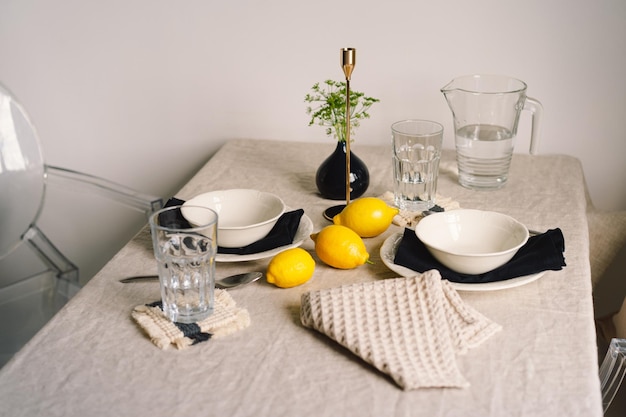 Vintage nakrycie stołu z lnianymi serwetkami i żółtymi cytrynami Dekoracja stołu z bliska Przytulny spokojny posiłek rano w promieniach słońca