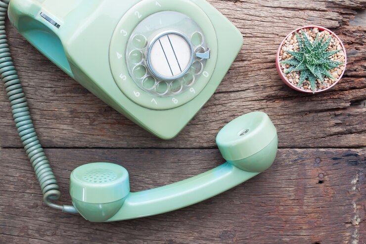 Zdjęcie vintage telefon i kaktus roślina na drewnianym stole
