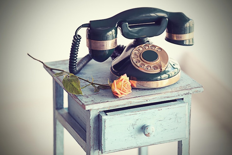 Zdjęcie vintage telefon na rustykalnym niebieskim stoliku nocnym