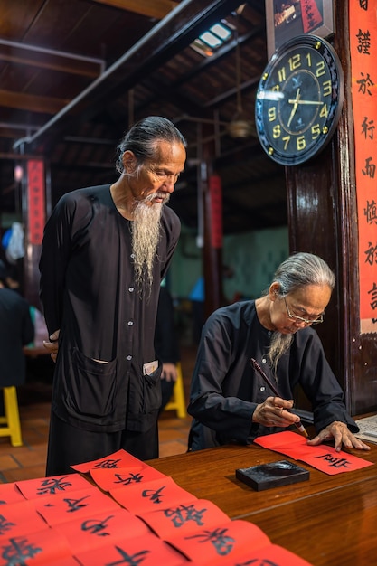 Vung Tau Wietnam 12 stycznia 2023 Wietnamski uczony pisze kaligrafię na Long Son Festiwal kaligrafii jest popularną tradycją podczas święta Tet Pisanie kupletów na Święto Wiosny nowy rok