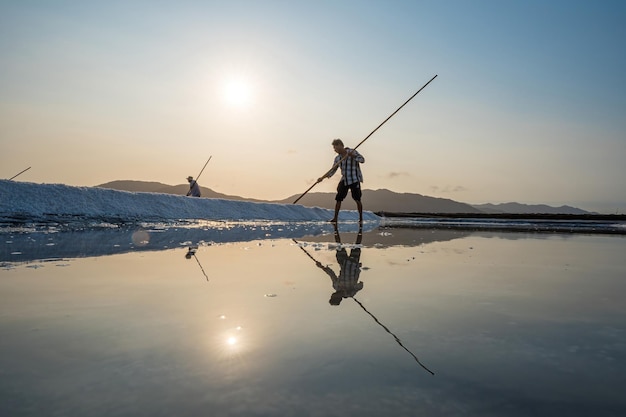 Vung Tau WIETNAM 18 MAR 2023 Proces soli morskiej wykonany ze stosu soli w solnisku przez pracownika na obszarach wiejskich pól Long Dien Salt jest jednym z najbardziej wyjątkowych miejsc w Wietnamie