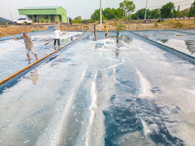 Vung Tau WIETNAM 25 LUTY 2023 Proces soli morskiej wykonany ze stosu soli w solnisku przez pracownika soli na obszarach wiejskich Long Dien Salt Fields to jedno z najbardziej wyjątkowych miejsc w Wietnamie