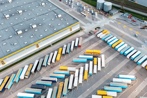 W bazowym centrum logistyczno-produkcyjnym zaparkowanych jest wiele ciężarówek i przyczep
