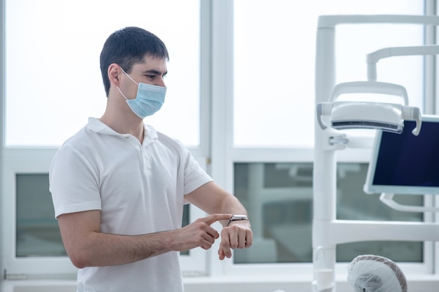 W gabinecie stomatologicznym. Młody mężczyzna dentysta w swoim gabinecie wygląda na zajęty