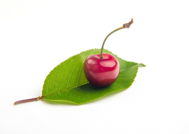 W kształcie serca wiśniowa jagoda na pięknym liściu odizolowywał wycinankę