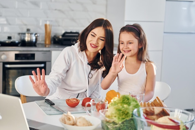 W kuchni młoda kaukaska mama z córką jest razem w domu