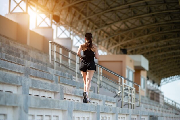 w średnim wieku Beautiful Sport Asian kobieta na zewnątrz lekkoatleta Runner działa na schodach stadionu aktywnego i zdrowego stylu życia.