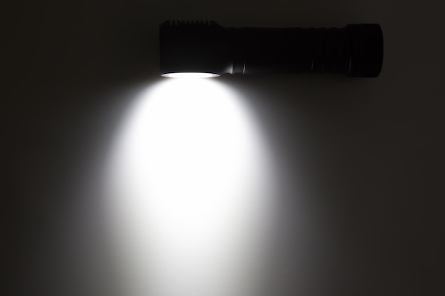 W zestawie latarka z wiązką światła na ciemnym tle kemping i przedmiot gospodarstwa domowego