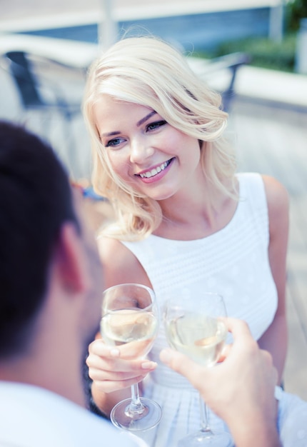 wakacje letnie i koncepcja randkowa - kobieta pijąca wino z mężczyzną w kawiarni w mieście