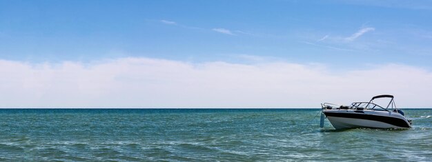 Wakacje morskie transparent pusta biała motorówka nad morzem na tle błękitnego nieba