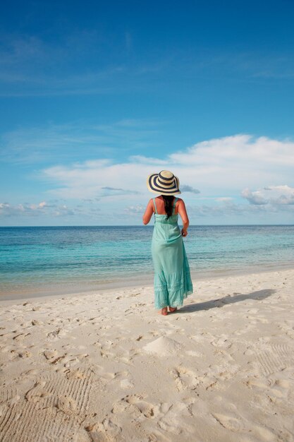 Wakacje na plaży. Dziewczyna spacerująca wzdłuż tropikalnej plaży na Malediwach.