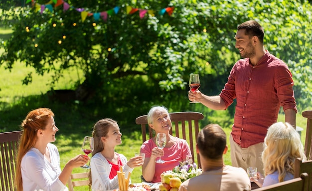 Zdjęcie wakacje rekreacyjne i ludzie koncepcja szczęśliwa rodzina z festiwalową kolacją lub letnią imprezą ogrodową i świętowaniem