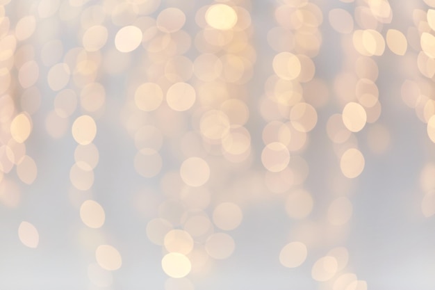 wakacje, tło i koncepcja oświetlenia - niewyraźne złote dekoracje świąteczne lub girlanda świeci bokeh