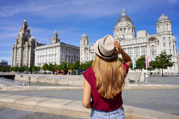 Wakacje w Liverpoolu w Wielkiej Brytanii Piękna młoda kobieta odwiedza Pier Head z Trzema Gracjami w centrum Liverpoolu w Anglii