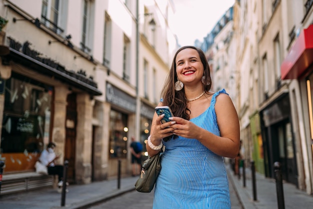 Wakacje w Paryżu Młoda dziewczyna bawi się w Paryżu we Francji Letnie wakacje w Europie Używając smartfona