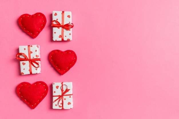 Wakacyjna kompozycja prezentowych pudeł i czerwonych tekstylnych serc na kolorowym widoku z góry na Walentynki