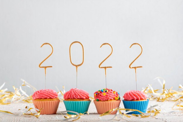 Wakacyjne Babeczki Oszronione Różowym Lukrem Buttercream Ze Złotymi Numerami 2022. Kartka świąteczna Z Babeczkami.