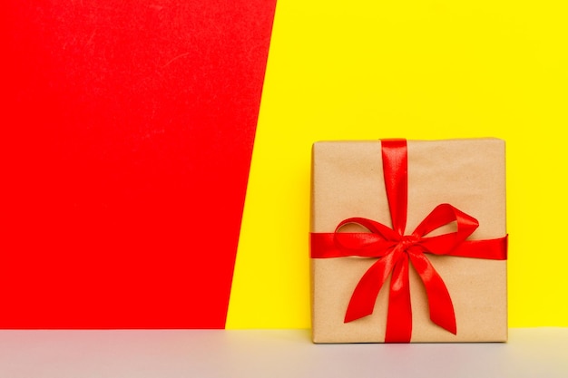 Wakacyjny brązowy papier obecny związany czerwoną wstążką łuk widok z góry z miejsca na kopię Płaski świecki tło wakacje Urodziny lub prezent świąteczny Koncepcja pudełko na prezent świąteczny z miejsca na kopię