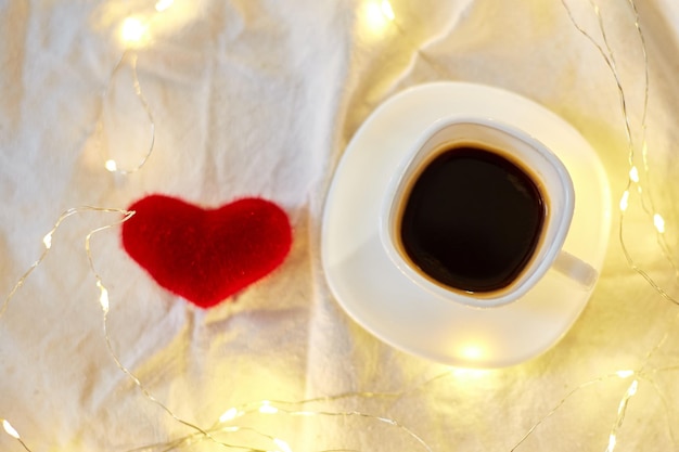 Walentynki Filiżanka kawy w łóżku z czerwonym sercem i miejscami do kopiowania Kartkę z życzeniami romantyczne śniadanie