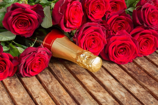 Walentynki karmazynowe czerwone róże i szyjka wina szampańskiego z bliska
